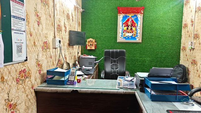 Reception and consultation area at the Harsiddhi Services office in Vadodara, with the Rate-us-on-Google board