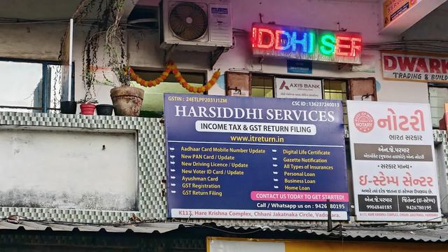 Harsiddhi Services office signboard in the evening at Chhani Jakatnaka Circle, Vadodara